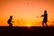 Father and son playing badminton in the evening, silhouettes of people exercising in nature