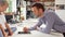 Father And Son Playing Game On Digital Tablet In Kitchen