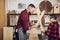 Father and son playing knights with wooden DIY swords at carpenter workshop