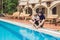 Father and son playing with a remote controlled boat in the pool