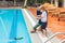 Father and son playing with a remote controlled boat in the pool