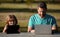 Father and son playing or studying with laptop in the park. Kid with daddy learning lesson. Blogging.