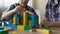 Father and son playing with toy cubes, building small house, great time together