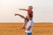 Father and son pointing into the distance. Child sits on his fathers shoulder on background of yellow field