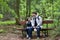 Father and son relaxing on bench after a hike in the woods