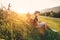 Father and son rest in high green grass after bicycle walk