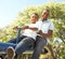 Father and Son Riding On SeeSaw In Park