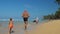 Father and son run along sea shore beach with palms