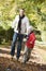 Father and son running along autumn path