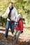 Father and son running along autumn path