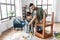 father and son sanding old table with sponge