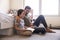 Father And Son Siting On Bedroom Floor Reading Book Together