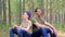 Father and son are sitting on forest stump and deeply breathing fresh air. Slow motion