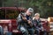 Father and son sitting in a pickup truck after hunting in forest. Dad showing boy mechanism of a shotgun rifle.