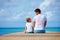 Father and son sitting on pier and talk