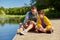 Father and son with smartphone on river berth