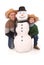 Father and son with snowman with scarf and hat