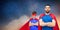 Father and son in superhero capes over night sky