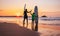 Father and son surfers stay on the sunset beach