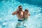 Father and son swimming in pool. Family at aquapark. Dad and son in pool. Summer weekend. Family leisure and summer