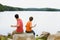 Father and son throwing rocks into lake