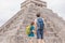 Father and son tourists observing the old pyramid and temple of the castle of the Mayan architecture known as Chichen