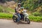 Father and son are traveling on a moped on a tea plantation in Malaysia. Traveling with children concept