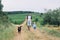 Father and son walking with dog on nature, outdoors.