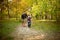 Father and son walking and having fun in autumn forest, look happy and sincere