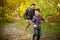 Father and son walking and having fun in autumn forest, look happy and sincere