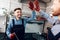 Father and son work at the auto service. Two mechanics work with the details of the car.