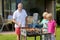 Father with sons grilling meat in the garden