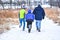 Father and Sons Hiking Through Snow Covered Nature Preserve