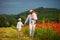 Father and sons walking through the poppy flower field at summer day