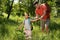 Father spraying tick repellent on little daughter`s arm during hike in nature