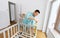 Father with tablet pc and ruler measuring baby bed