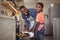 Father taking tray of fresh cookies out of oven with son in kitchen