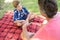 Father talking to son at picnic in park