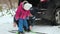 Father teaches daughter to ski. Family holiday in the winter forest.