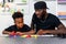 Father teaches and helps his son study how to wire an electrical circuit at home. Parental guidance, Homeschooling and being a