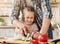 Father teaching daughter to cut a cucumber