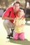 Father Teaching Daughter To Play Golf