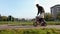 Father teaching daughter to ride bike at urban park. Child girl learning biking with the dad`s help.Family and childhood