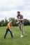 Father teaching happy son playing badminton outdoors