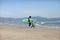 father teaching his child surfing on the beach by the sea. excited girl or boy doing execises developing new skills