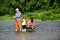 Father teaching his son fishing against view of river and landscape. Fishing in river. Summer weekend. Father and son