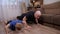 Father teaching kid son doing push-ups exercises at home.