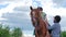 Father teaching little son to sit on horse and holding a rein in hands