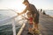 Father teaching little young son to be a fisherman, fishing together on sea dock embankment enjoying and learning using the fish r