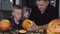 Father teaching son how to carve pumpkins for halloween